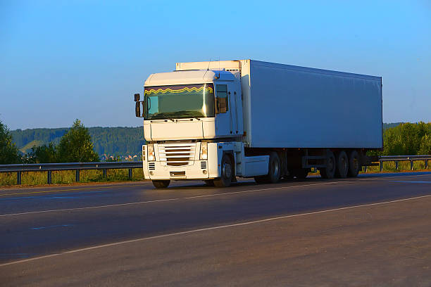 white truck transports freight on the country highway